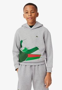 Felpa grigia in cotone con una grafica frontale in verde e rosso che presenta forme geometriche. Include anche pantaloni grigi coordinati.