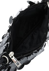 Borsa a pochette nera con un esterno di paillettes e un design circolare. L'interno è foderato in tessuto nero, con chiusura a zip e accessori in argento.