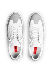 Sneaker in pelle bianca e grigia con design a lacci, linguetta imbottita e un logo rosso prominente sulla soletta. Texture liscia, forma sportiva.