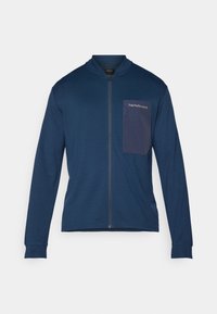 Marineblaue Zip-Jacke aus weichem Stoff, mit Stehkragen, langen Ärmeln und einer aufgesetzten Tasche mit Logo auf der linken Brust.