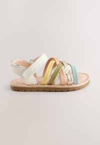 Sandałki na paskach z białymi, skórzanymi paskami na kostkę i palce; posiadają wielokolorowe paski w pastelowych odcieniach i metalicznym wykończeniu. Płaska podeszwa z przyczepną powierzchnią.