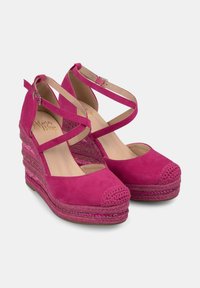 Scarpe con zeppa in suede fucsia, con design a cinturino incrociato, punta arrotondata e dettagli intrecciati sul tacco della zeppa. Fodera interna liscia.