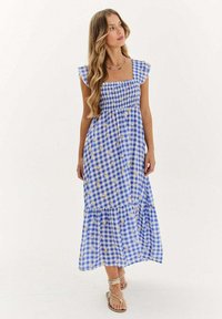 Modrá a biela jednofarebná maxi šaty s krátkymi volánovými rukávmi, smockovaným živôtikom a vrstvenou sukňou. Obsahuje kvetinový vzor po celom povrchu.