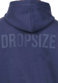 Navy blue hoodie made of cotton blend, featuring a large embossed "DROPSIZE" text on the back. Smooth texture and relaxed fit.