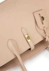 Borsa a tracolla in pelle beige con finitura testurizzata, dotata di chiusura in metallo dorato e etichetta con logo, e doppi manici resistenti per il trasporto.