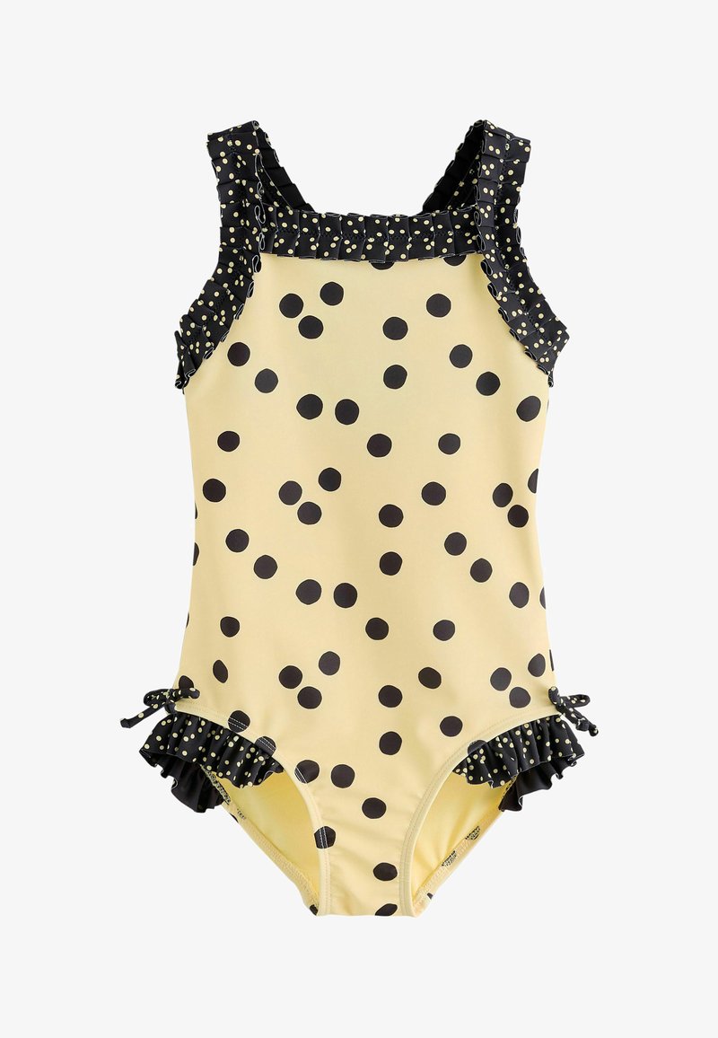 Maillot de bain jaune à pois avec bretelles et accents noirs à volants, orné de nœuds noirs sur les ouvertures des jambes. Le matériau semble extensible et lisse.