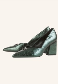Paire de chaussures à talons blocs vert métallisé à bout pointu, finition texturée, avec une petite boucle argentée décorative sur chaque empeigne.