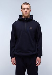 Felpa con cappuccio blu navy con zip a metà sul fronte, con un'etichetta del logo sul petto e polsini a costine. Tessuto morbido e texture.