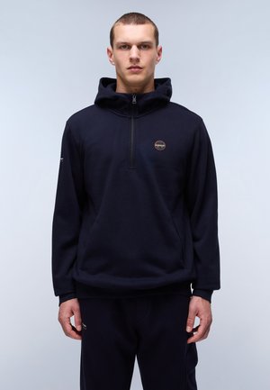 Navy hooded sweatshirt with a half-zip front, featuring a logo patch on the chest and ribbed cuffs. Soft, textured fabric.