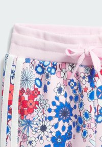 Růžová látka s květinovým vzorem, obsahující modré, červené a bílé květiny. Elastický pas s růžovou stuhou a bílými postranními pruhy. Měkká textura.