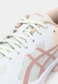 Λευκό και μπεζ παπούτσι για τρέξιμο Asics με ανοιχτό ροζ λογότυπο, υλικό από δίχτυ και λευκά κορδόνια δεμένα πάνω από τη γλώσσα.