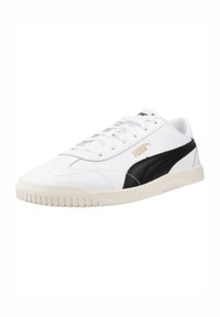 Zapatillas de cuero blanco con acentos negros, franjas laterales texturizadas, cierre de cordones y suela de goma. Logo de PUMA en dorado en el lateral.