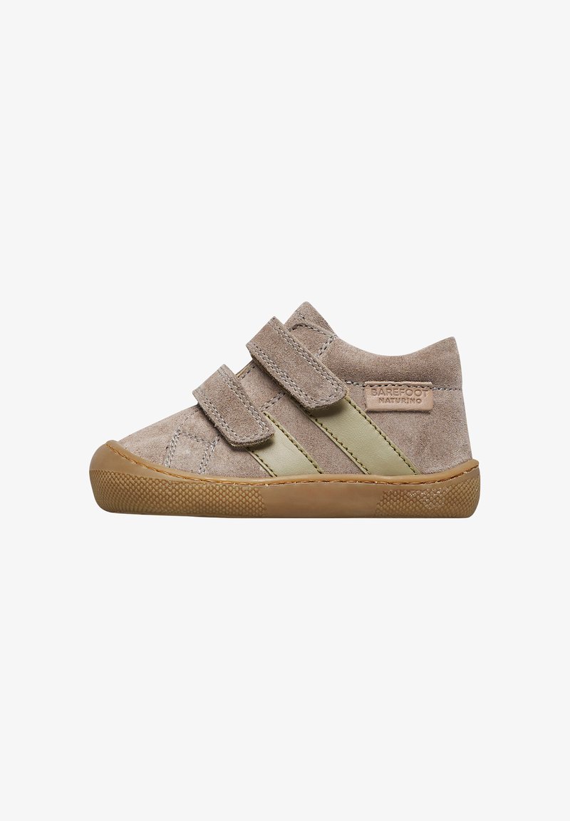 Scarpe per bambini in suede color sabbia con due cinturini in Velcro, caratterizzate da un accento in pelle verde e suola in gomma testurizzata per una migliore aderenza.