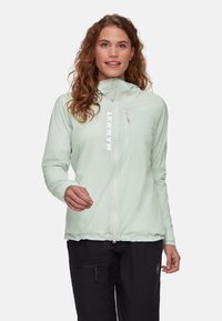 Giacca da outdoor verde menta chiaro con colletto alto, zip anteriore e orlo elasticizzato. Presenta un logo sul petto e una superficie in tessuto liscia e strutturata.