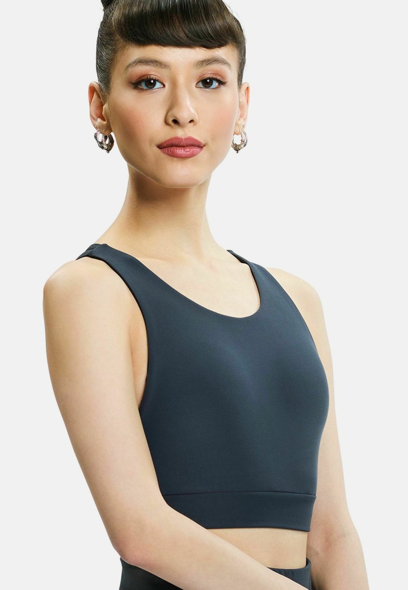 Zwarte sportieve crop top met een ronde halslijn, brede schouderbanden en een gladde textuur. Eenvoudig ontwerp, getailleerde pasvorm en geen zichtbare patronen.