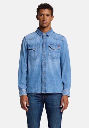 Lichtblauwe denimshirt met een knoopsluiting aan de voorkant, twee borstzakken en een klassieke kraag. Lange mouwen met standaard manchetten.