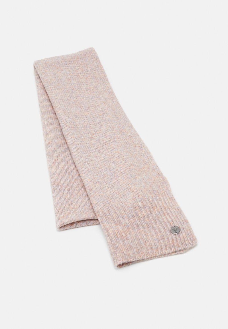 Écharpe en laine beige tricotée douce avec des bords côtelés et une petite étiquette ronde en métal avec logo à une extrémité, posée à plat sur un fond blanc.