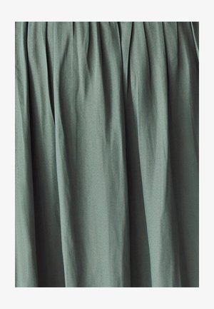 Grønne plisserede stof med en glat tekstur. Materialet har en subtil glans og falder blødt, hvilket skaber blide folder overalt.