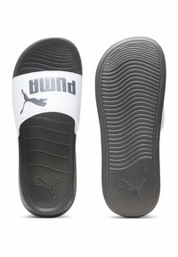 Puma japanke imaju bijeli remen s sivim logotipom, crne teksturirane potplate, profilirani unutrašnji dio i valoviti uzorak potplata.