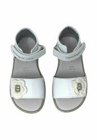 Infradito bianchi in pelle con cinturini regolabili, dettagli argentati e un design floreale che presenta un'applicazione a forma di 'B' sul davanti.