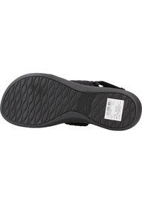 Zwarte sandaal met een textuur rubberen zool, een geweven stoffen bovenkant, een verstelbaar bandje en Clarks-branding op de zool.