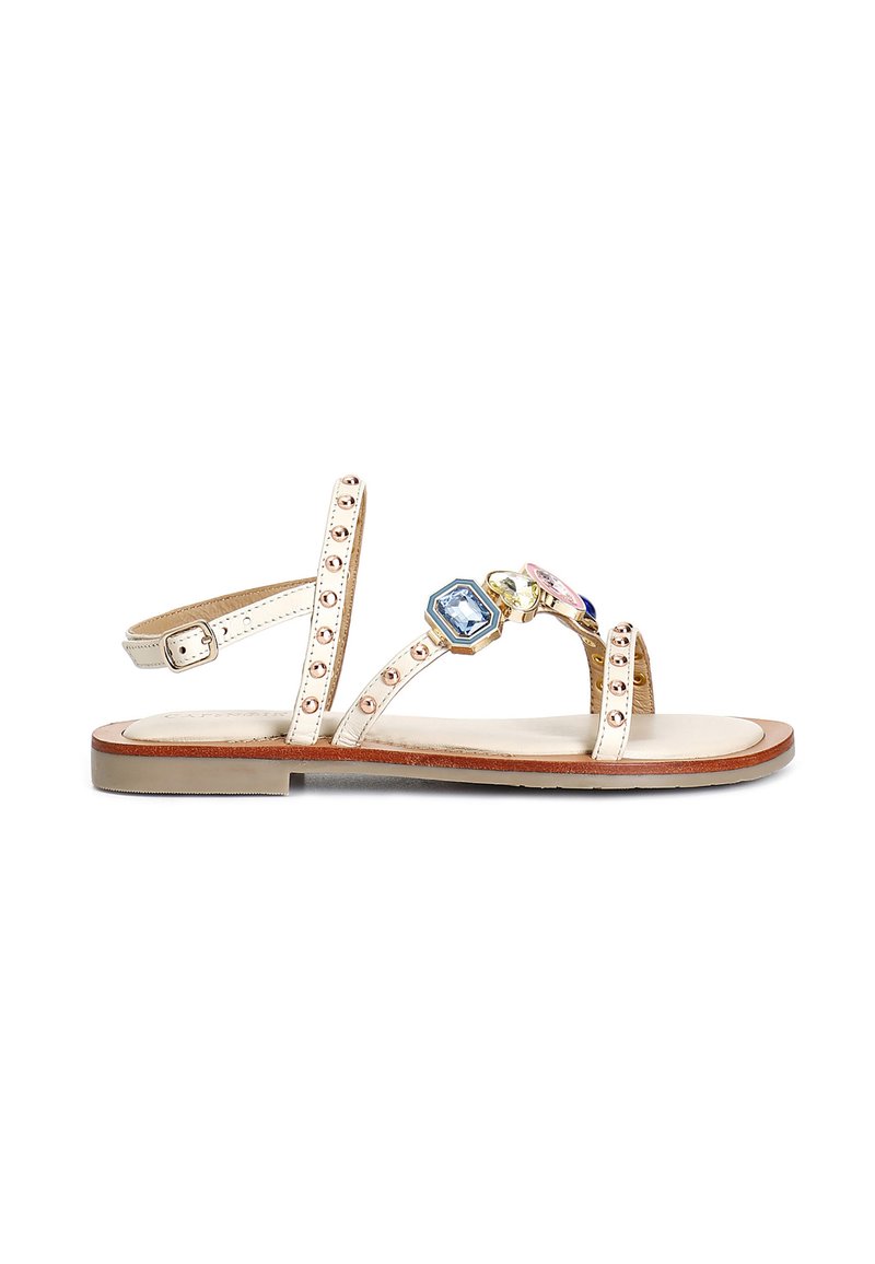 Sandali piatti con una finitura metallica beige, caratterizzati da tre gemme decorative, cinturini borchiati e una soletta imbottita.