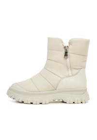 Bottes isolées beiges avec une fermeture éclair sur le côté. Fabriquées en matériau matelassé, elles disposent d'une épaisse semelle en caoutchouc avec un motif de semelle robuste.