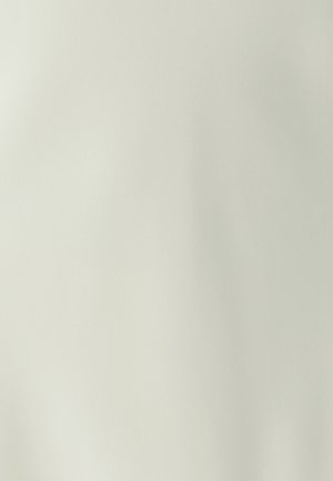 Smooth light beige fabric with subtle texture and soft folds in natural lighting.