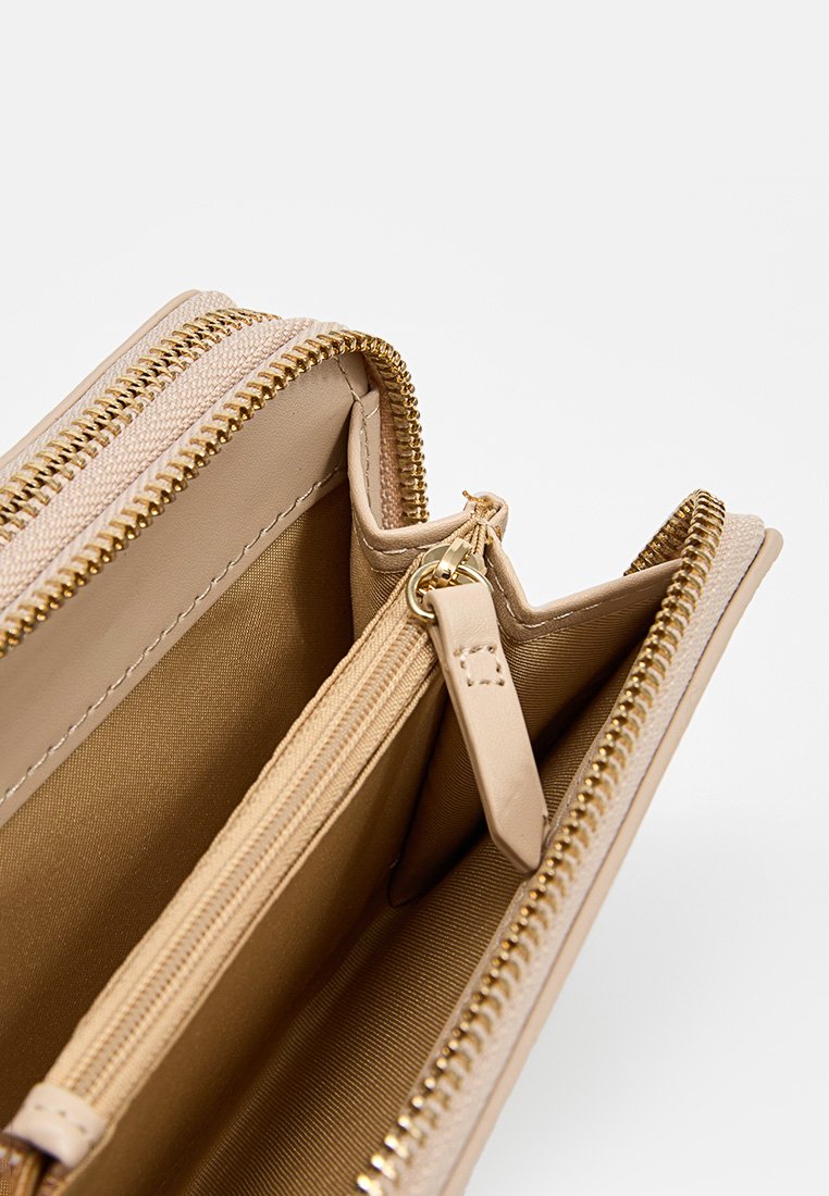 Beige Leder Geldbörse mit goldenen Beschlägen, ausgestattet mit mehreren Fächern, einschließlich eines Reißverschlussfachs und einem glatten Innenfutter.