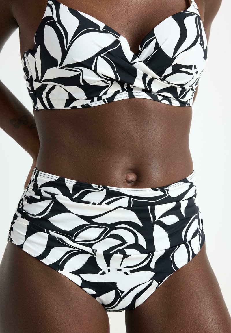 Sort og hvid bikini med et blomstermønster. Materialet ser glat ud med en struktureret design. Toppen har en samlede buste med brede stropper.