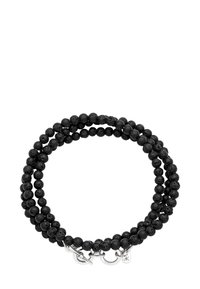 Svart pärlarmband med matt strukturerade runda pärlor och silverfärgad lås, virad två gånger i en cirkel.