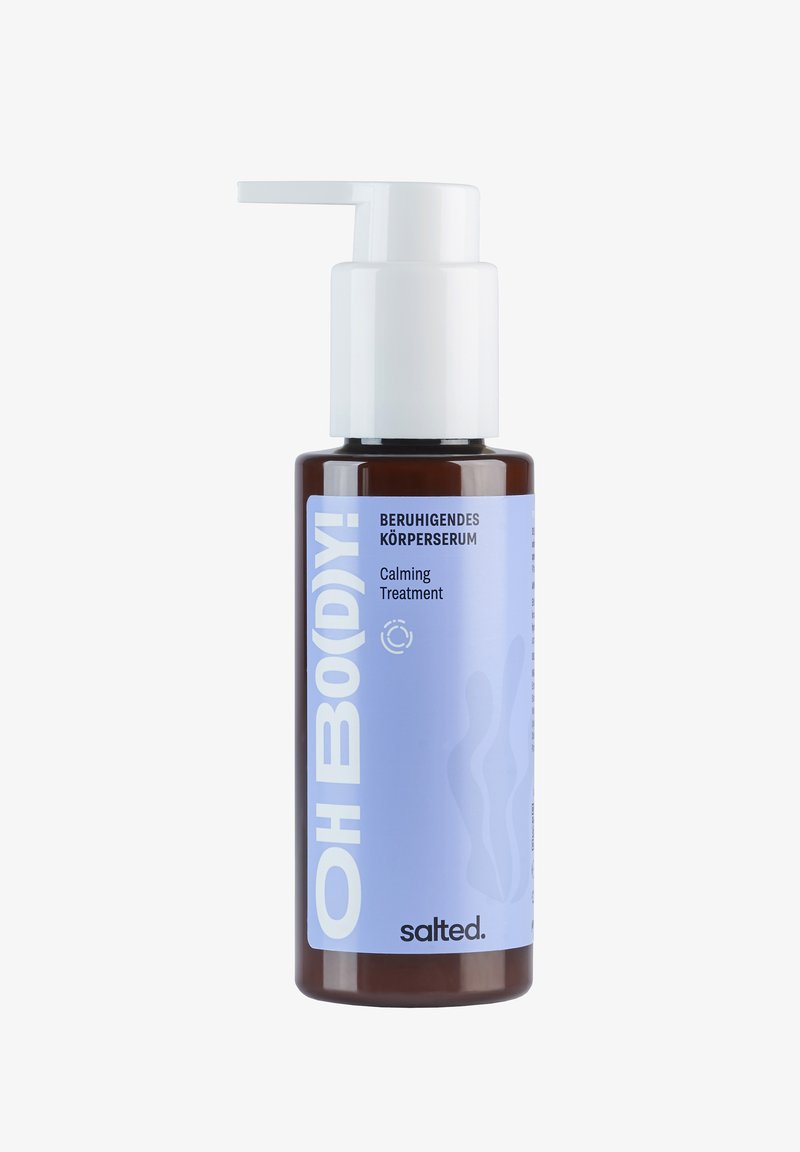 Bruine glazen fles met een witte pompdispenser. Het label heeft een lichtblauwe achtergrond met de tekst "OH BO(DY)!" en "Kalmerende Behandeling."