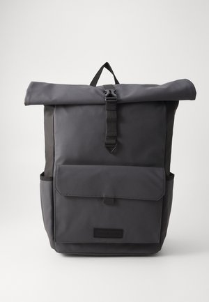Szary plecak z rolowanym zapięciem, z regulowanym paskiem, przednią kieszenią oraz podwójnymi kieszeniami bocznymi, wykonany z trwałego materiału nylonowego. Prosty design z minimalistycznymi akcentami.