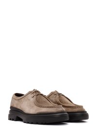 Chaussures en daim marron clair avec un bout arrondi, semelle en caoutchouc noire contrastante et détails brodés sur la tige.