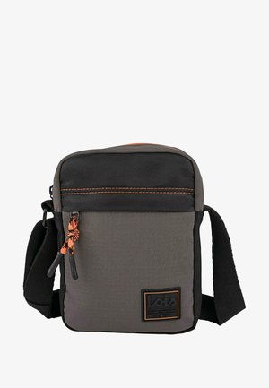 Bolso bandolera gris hecho de tela texturizada con una sección superior negra, costuras naranjas y un parche con el logo. Cuenta con una correa ajustable y cremallera.