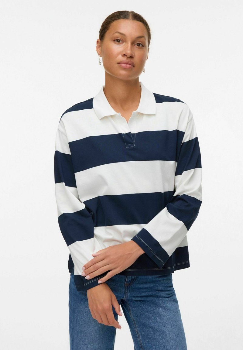 Polo a maniche lunghe in righe navy e bianche, con colletto, tessuto robusto e polsini a contrasto con dettagli di cucitura in vista.