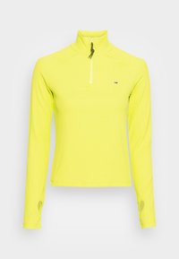 Long-sleeve, zippered pullover in bright yellow with ribbed texture and thumb holes at cuffs. Features a small logo on the chest.