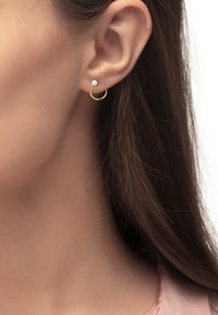 Goldene Creolenohrringe mit einem kleinen Perlenakzent, kreisförmiger Form, glatter Oberfläche und polierter Verarbeitung, die am Ohrläppchen getragen werden.