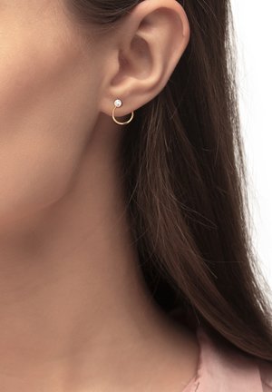 Goldene Creolenohrringe mit einem kleinen Perlenakzent, kreisförmiger Form, glatter Oberfläche und polierter Verarbeitung, die am Ohrläppchen getragen werden.