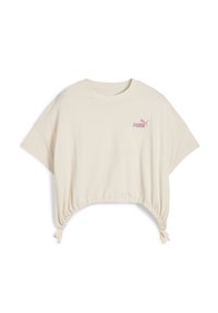 Camiseta de algodón color crema con un corte holgado. Presenta mangas cortas, un dobladillo recortado con detalles de cordón y un logo de Puma en color rosa.
