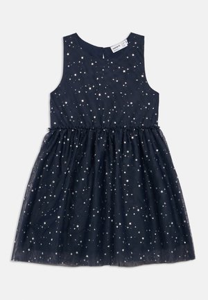 Robe bleu marine sans manches avec taille froncée et superposition, décorée de motifs d'étoiles blanches sur toute la surface.