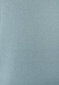 Hellblaues Gewebe mit glatter Textur, fein gestrickt mit gleichmäßigen Stichen. Das Material wirkt weich und elastisch.