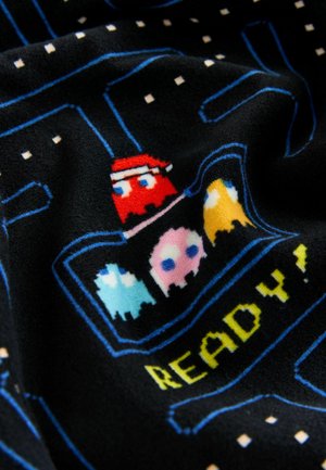 Fleecefilt med en svart bas och ett pixelerat Pac-Man-mönster, inklusive färgglada spöken och texten "REDO!" i klar gult.