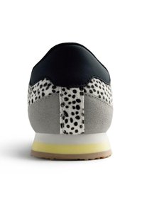 Sneaker con tomaia in pelle nera, corpo in suede grigio e dettagli in pelliccia maculata; suola gialla e bianca con finitura strutturata.