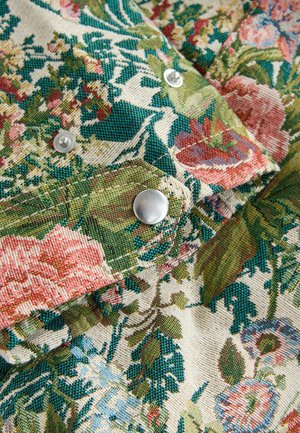 Floral-patterned fabric with rich hues of green, pink, and blue; includes silver snap buttons and a textured weave.