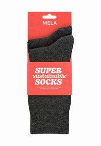 Chaussettes en coton gris foncé, emballées avec une étiquette rouge vif. L'étiquette indique "CHAUSSETTES SUPER durables", avec des détails sur les matériaux et la certification.