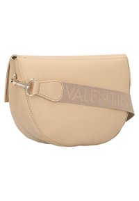 Béžová kožená kabelka přes rameno zaobleného tvaru, se stříbrnými kovovými doplňky a textilním popruhem s vyraženým nápisem "VALENTINO". Hladká textura.