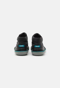 Black high-top sneakers with a textured upper, featuring a blue accent around the sole and branded heel detail. Rubber sole.