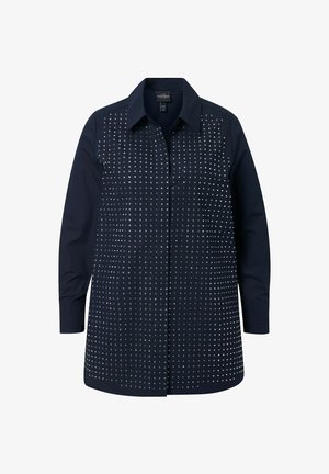 Chemise bleu marine à manches longues, avec un col et une fermeture à boutons. Présente un motif de clous en argent sur la poitrine et le dos.
