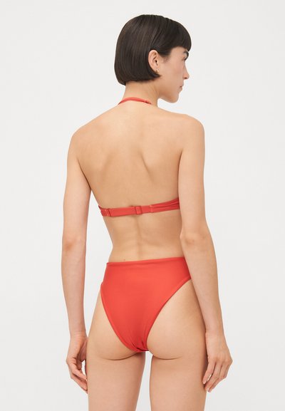 Sarkana bikini komplekts, kas sastāv no haltera topa ar regulējamiem siksnām un augstiem bikšiem. Gluda tekstūra ar minimālistisku dizainu un bez printiem.